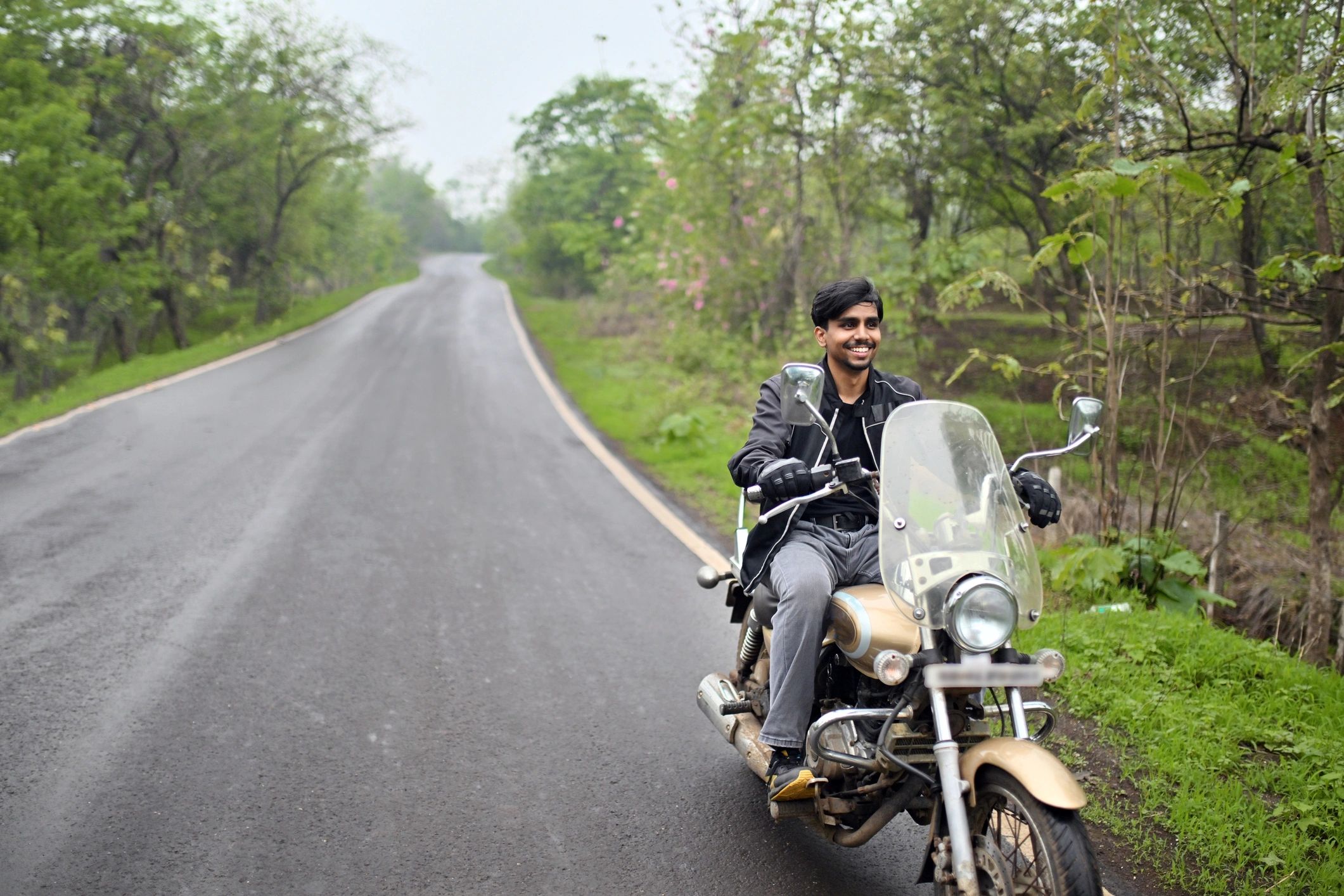 Motorcycle rider wearing protective jacket on a country road